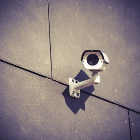 Security camera on gray office building wall